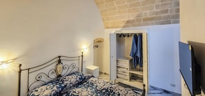 A bedroom with a bed, a wardrobe, and a television. - Monte Bello Suites (Montescaglioso)