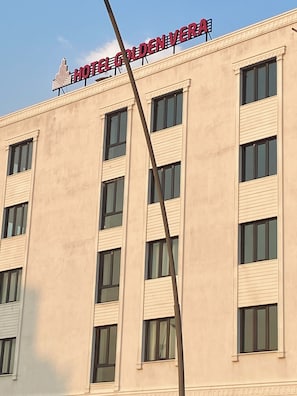 Un edificio con un cartel que dice 'HOTEL GOLDEN VERA' y varias ventanas.