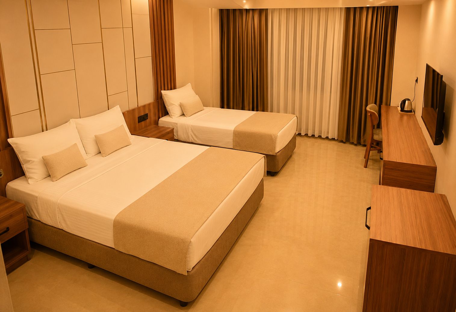 Quarto de hotel com duas camas, uma escrivaninha e uma televisão.