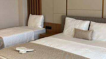 A hotel room with two beds, a wooden headboard, and a neutral color scheme.
