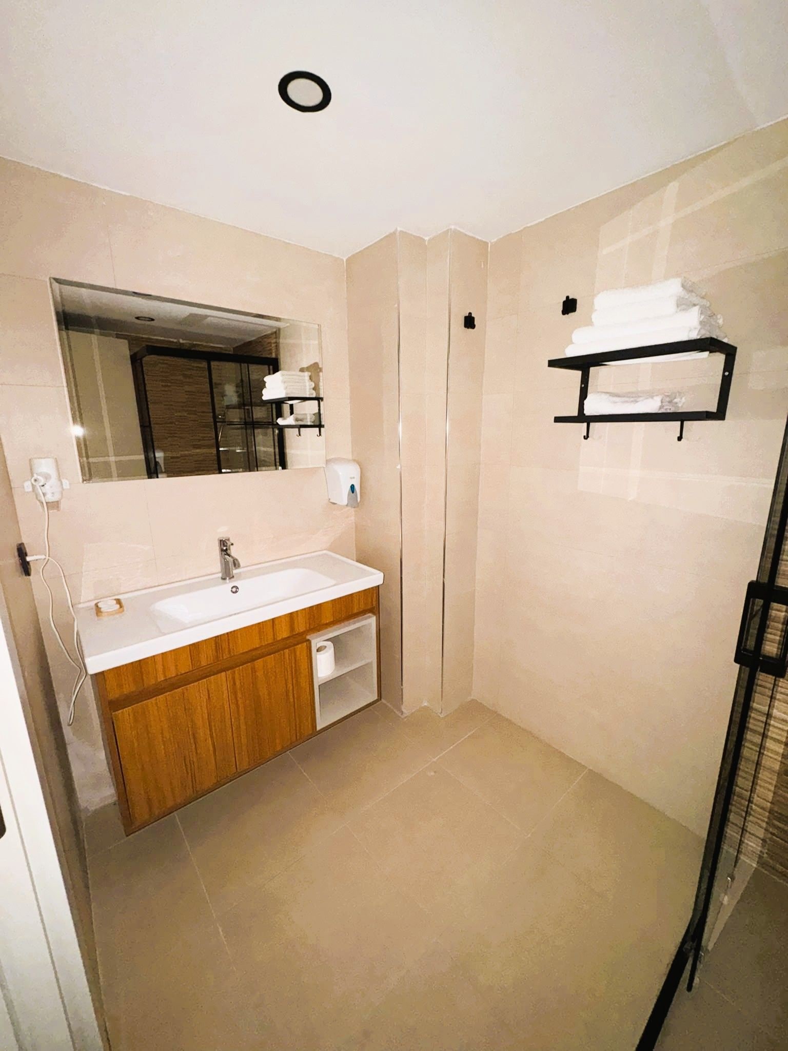 A modern bathroom with a sink, mirror, and towel rack.
