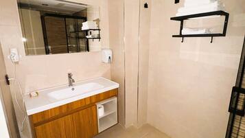 A modern bathroom with a sink, mirror, and towel rack.