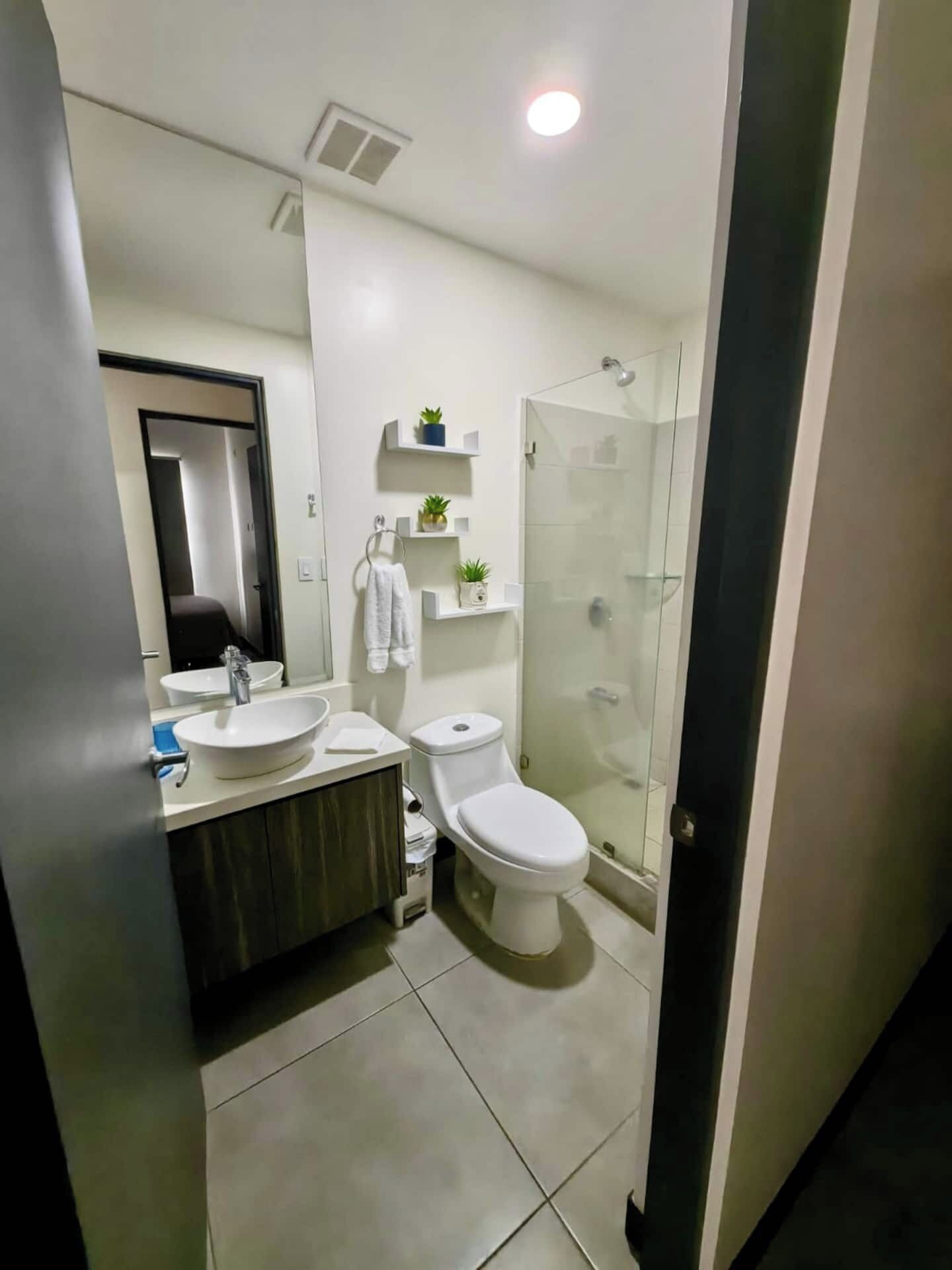 Ein modernes Badezimmer mit Waschbecken, Toilette und einer Duschkabine.
