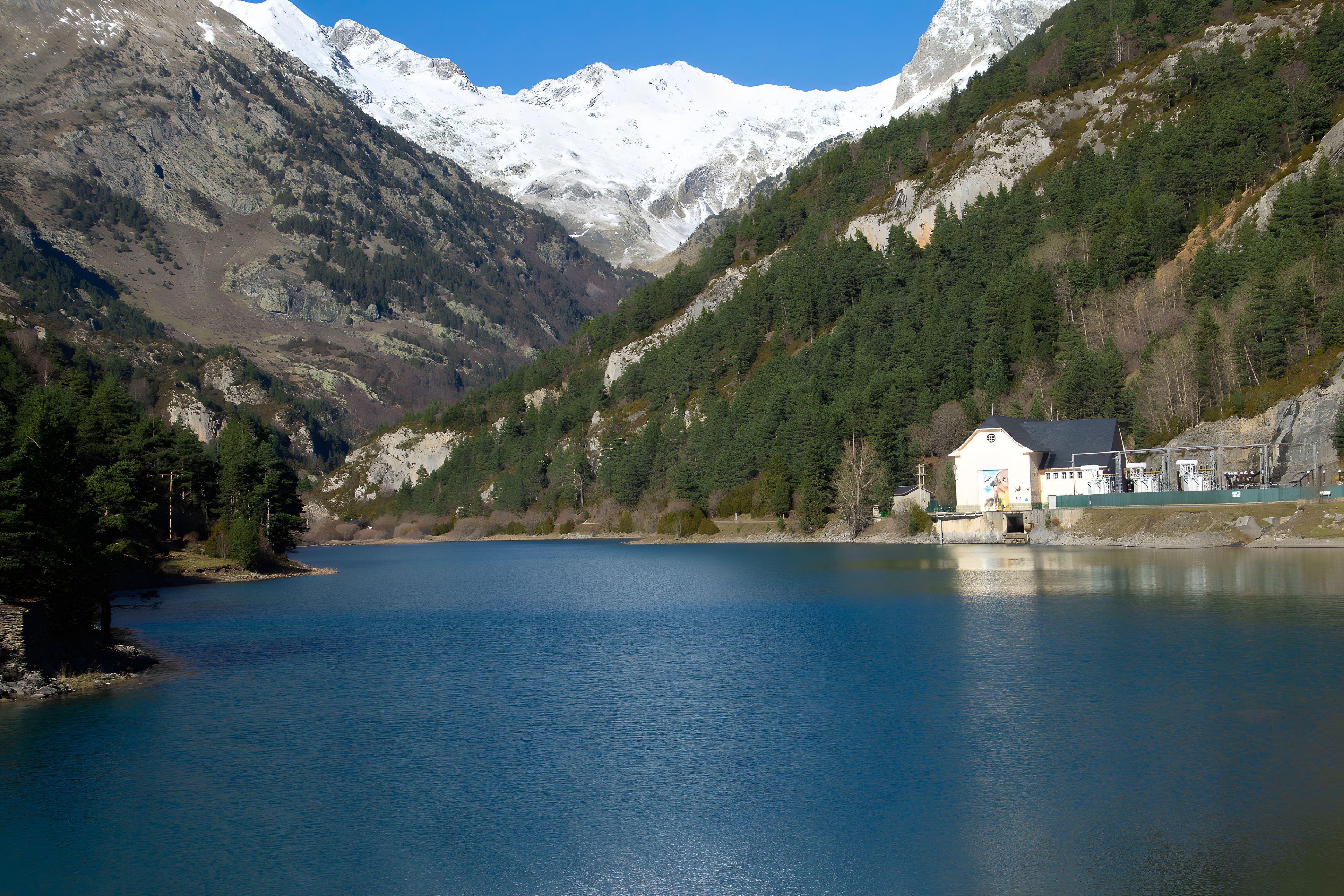 Um lago de montanha com uma cabana na margem.