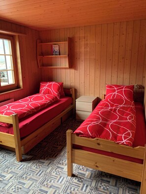 A room with two wooden bunk beds, a small wooden shelf, and a window. - Alpenglühn Appartement/Fewo, Bad, WC, 3 Schlafräume by Interhome (Adelboden)