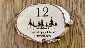 A wooden coaster with the number 12 and the text 'Waldeck Landgasthof Pension' on it.