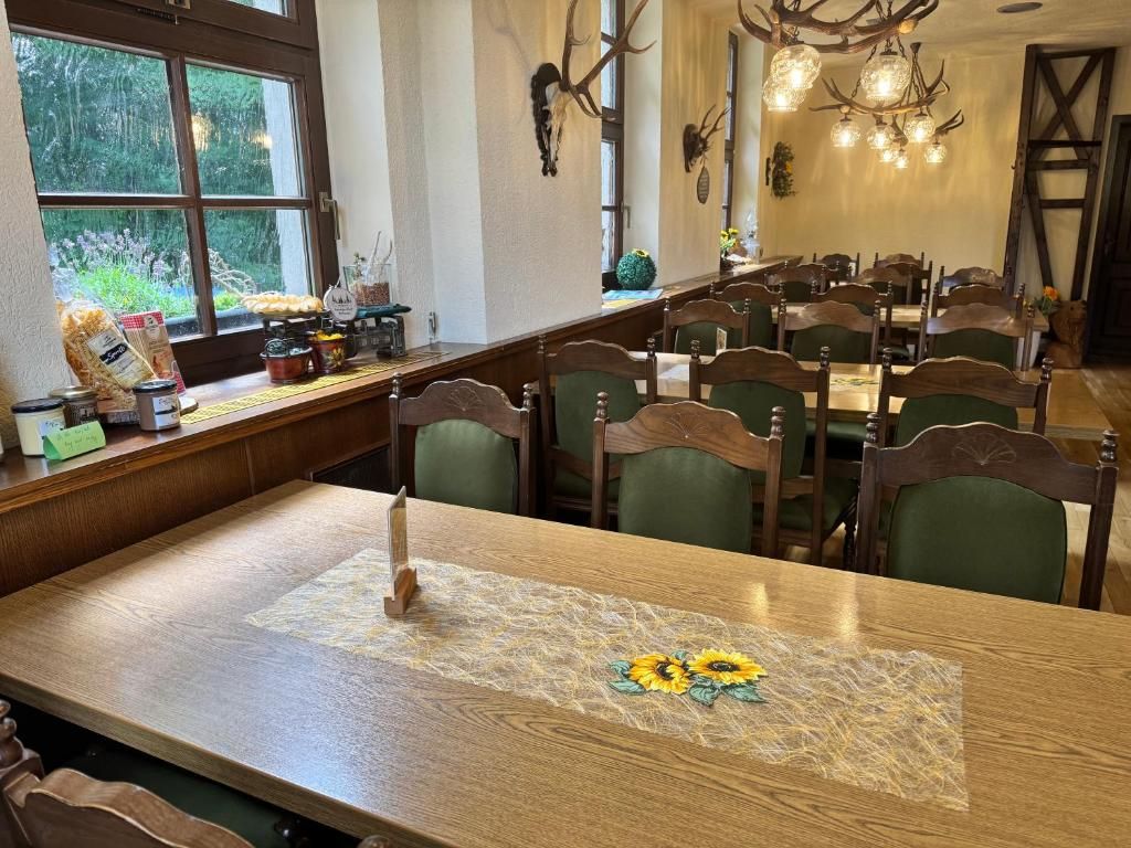 Ein Essbereich mit Holztisch, Stühlen und einem Fenster mit Blick auf Grünflächen.