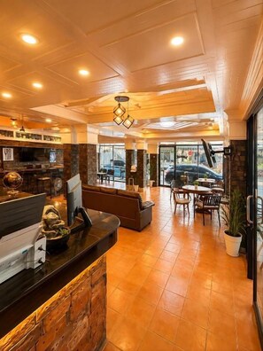 Um restaurante com área de bar, assentos e vista para a rua.