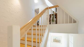 A staircase with wooden steps and white railings leading to an upper level.