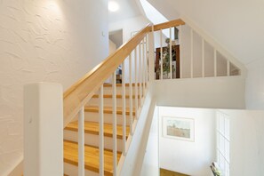 A staircase with wooden steps and white railings leading to an upper level. - Apartment “Welcome” with Private Rooftop Terrace (Olpe)