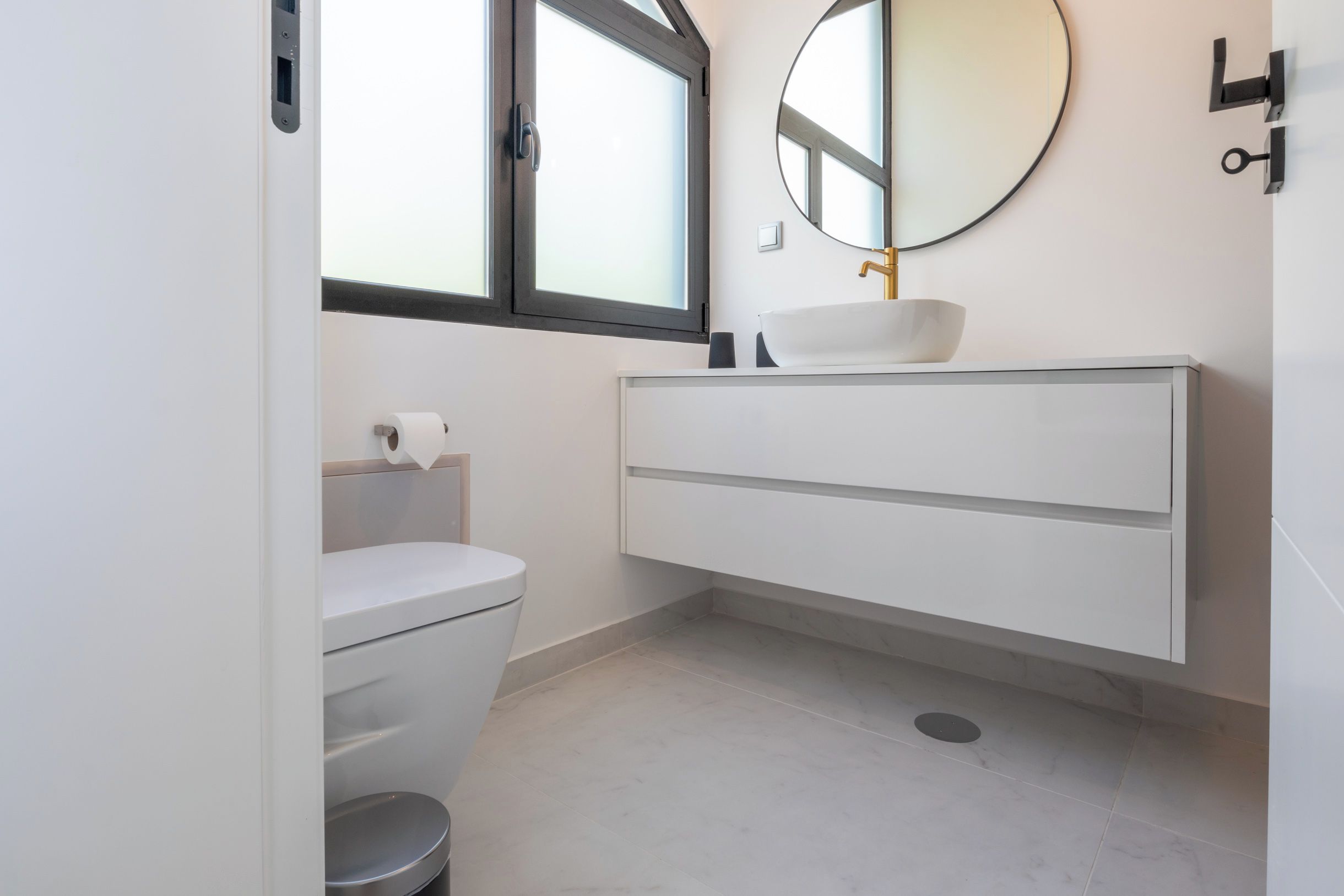 A modern bathroom with a toilet, bidet, and a vanity with a sink.