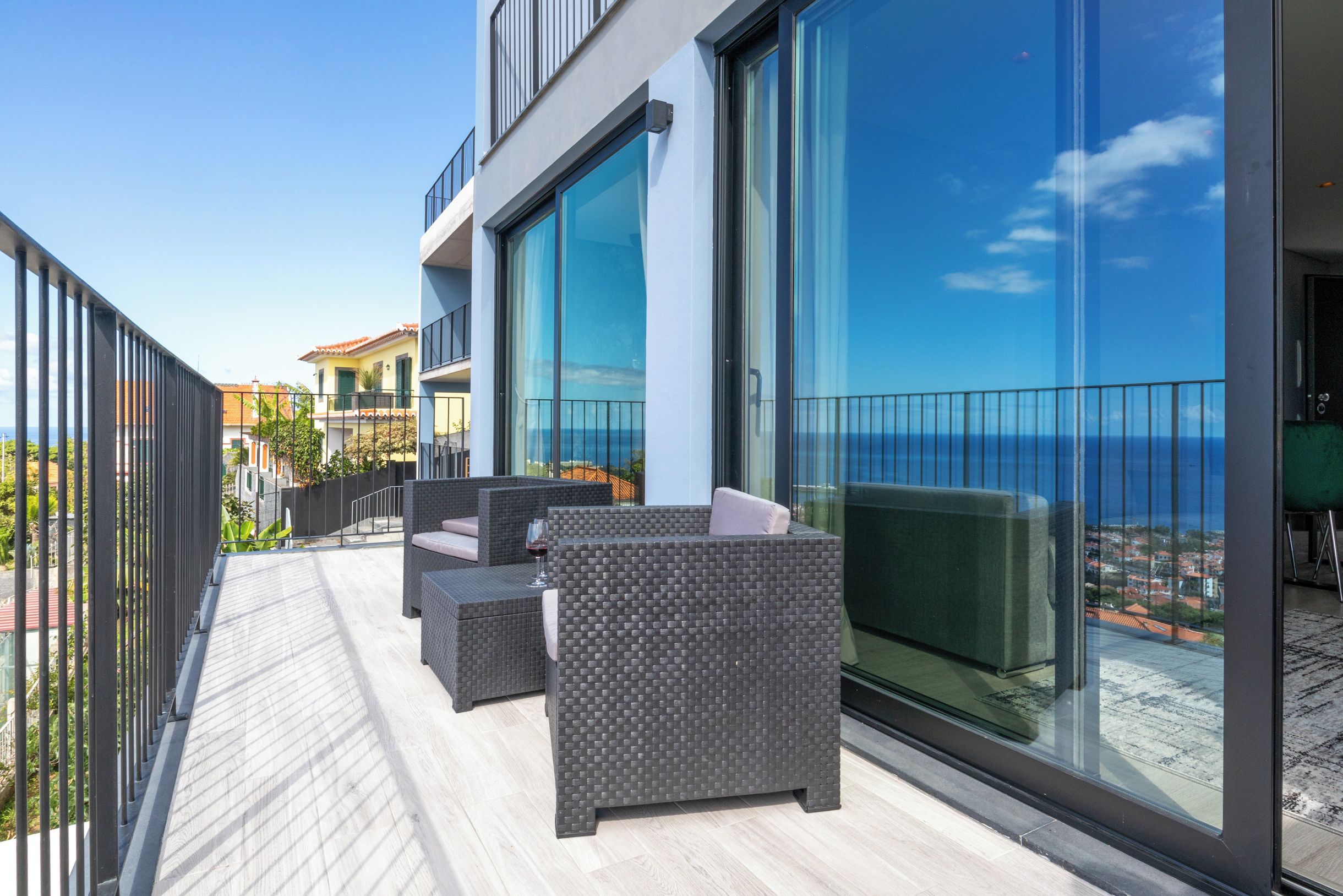 Un balcon aménagé avec du mobilier d’extérieur et une porte vitrée donnant sur une terrasse.
