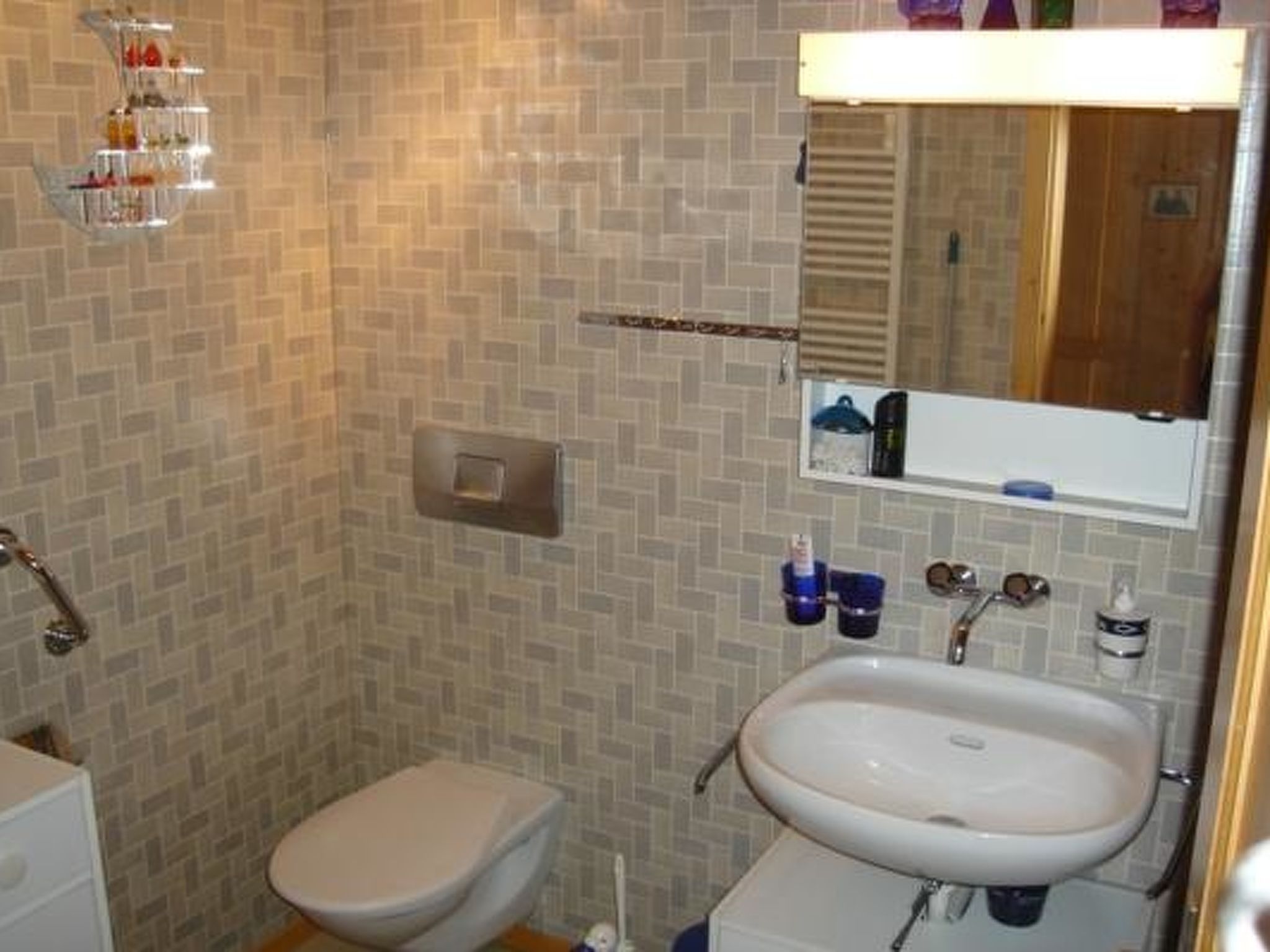 A bathroom with a toilet, sink, and shower area.