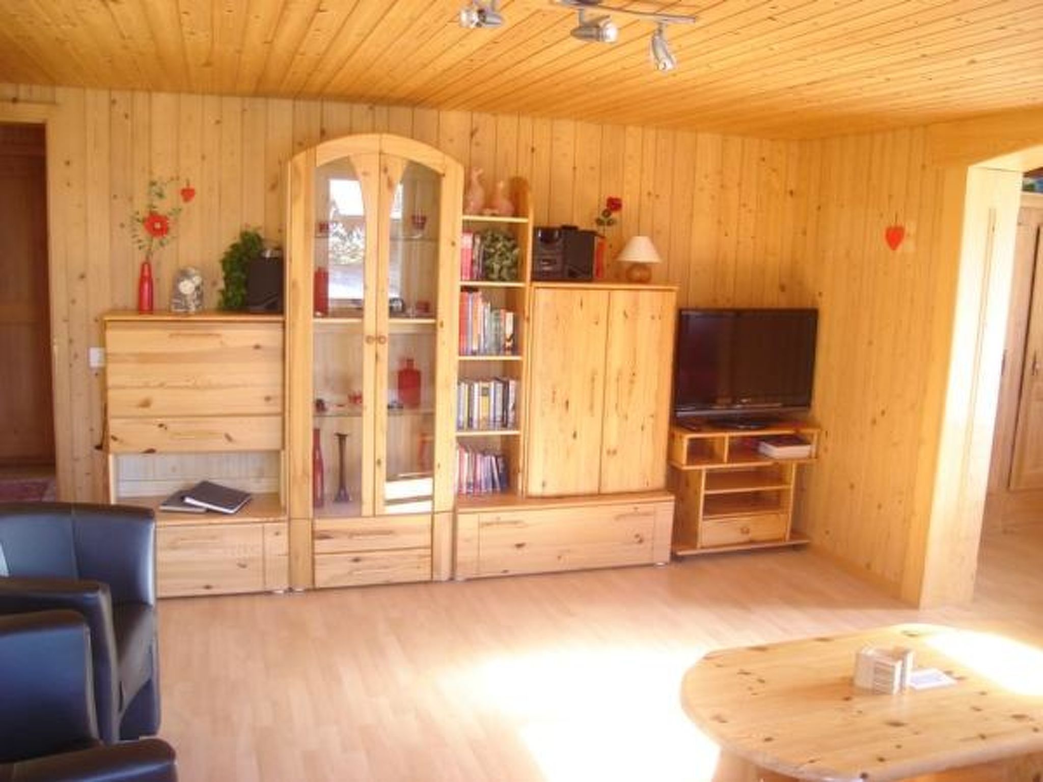 Une pièce aux murs lambrés, équipée d’un téléviseur, d’une bibliothèque et d’un bureau.