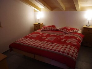 A bedroom with a bed, two bedside tables, and two wall-mounted lamps. - Anno Domini Appartement/Fewo, Dusche und Bad, WC, 2 Schlafräume 2-Zimmer Studio by Interhome (Adelboden)