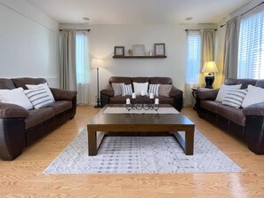 A living room with two brown sofas, a wooden coffee table, and a patterned rug. - Big family home near the park (Elk Grove)