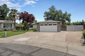 A residential driveway leading to a garage with a covered carport. - Clean Modern Living | College-Glen Gem Near River (Sacramento)