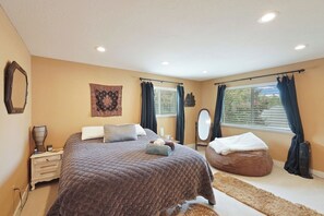 A bedroom with a large bed, a bedside table, a mirror, and a window with curtains. - Cozy Rustic Retreat with Pool in the heart of Sac (Sacramento)
