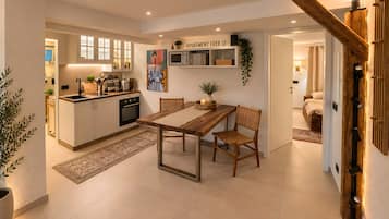 Een moderne keuken met witte kastjes, een houten eettafel en een keukeneiland.