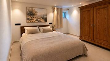 Ein Schlafzimmer mit einem großen Bett, einem Holzschrank und einem Gemälde an der Wand.