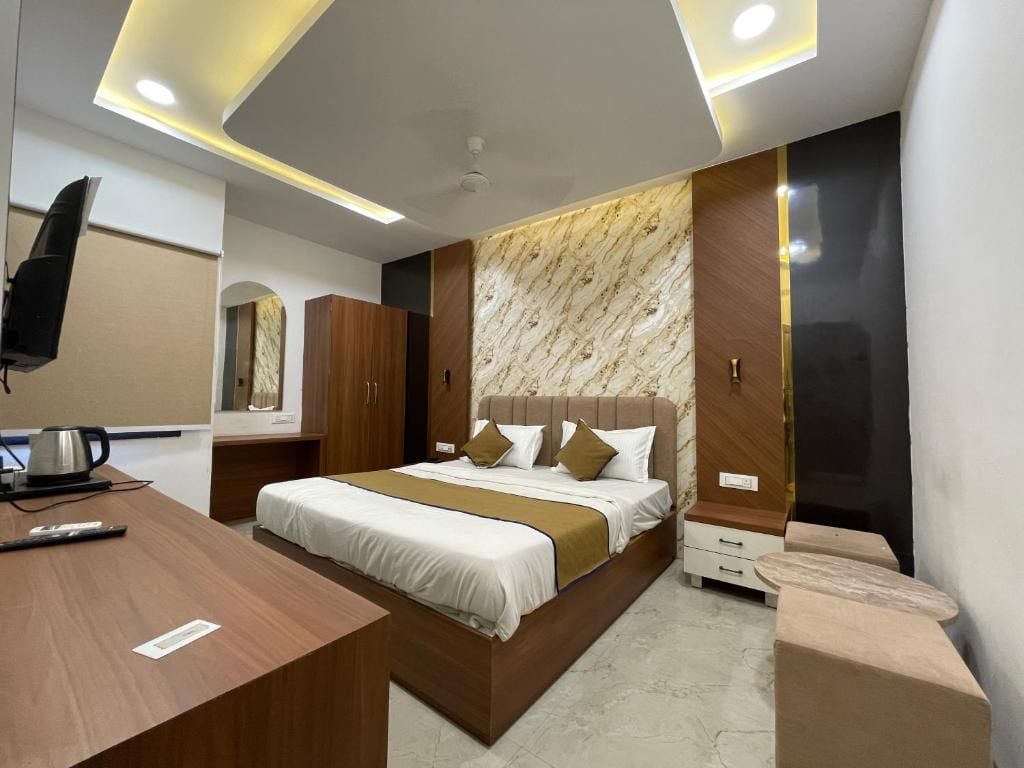 Una habitación de hotel moderna con cama, mesita de noche y escritorio con hervidor.