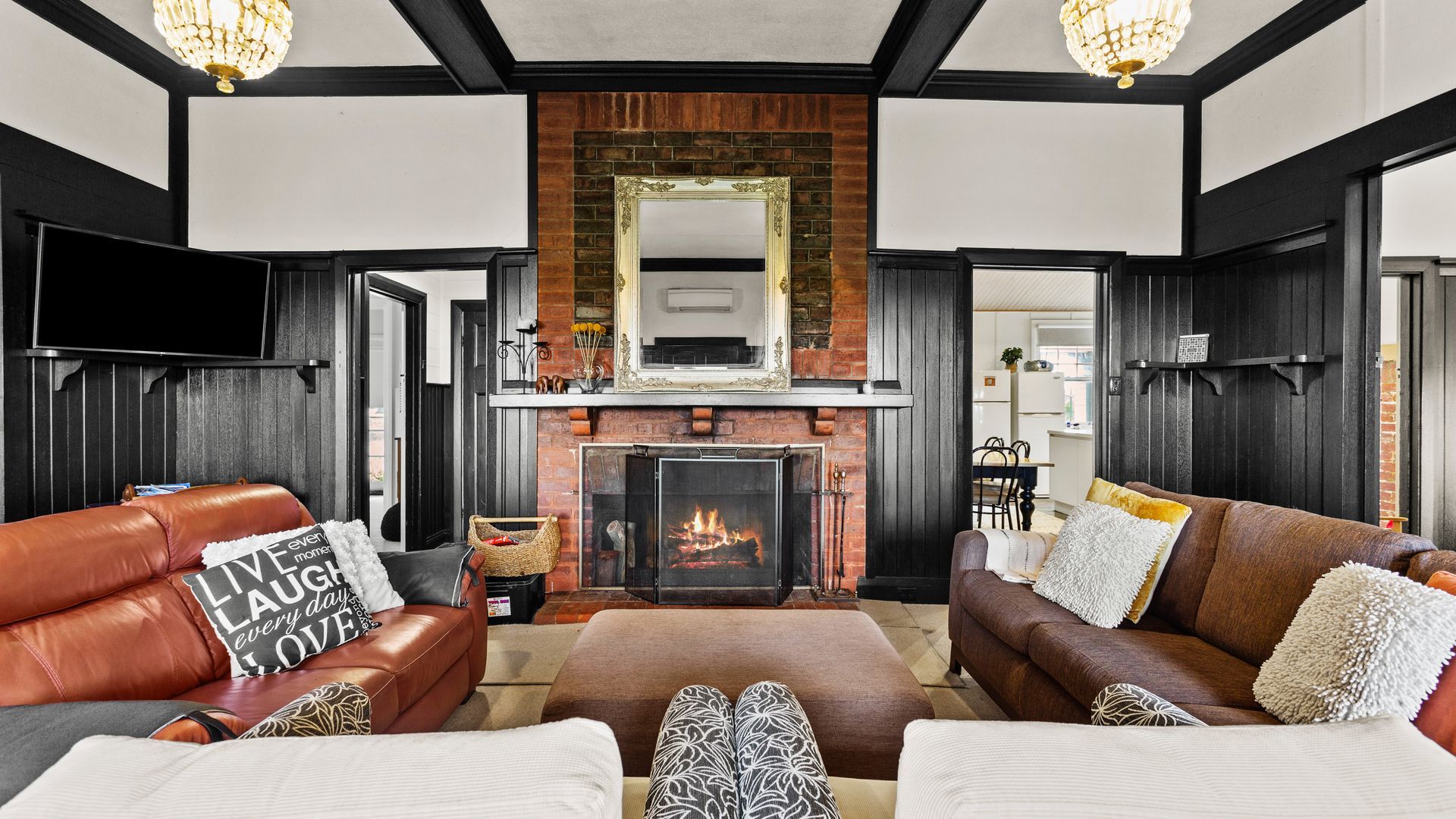 A living room with a fireplace, leather sofas, and a television.