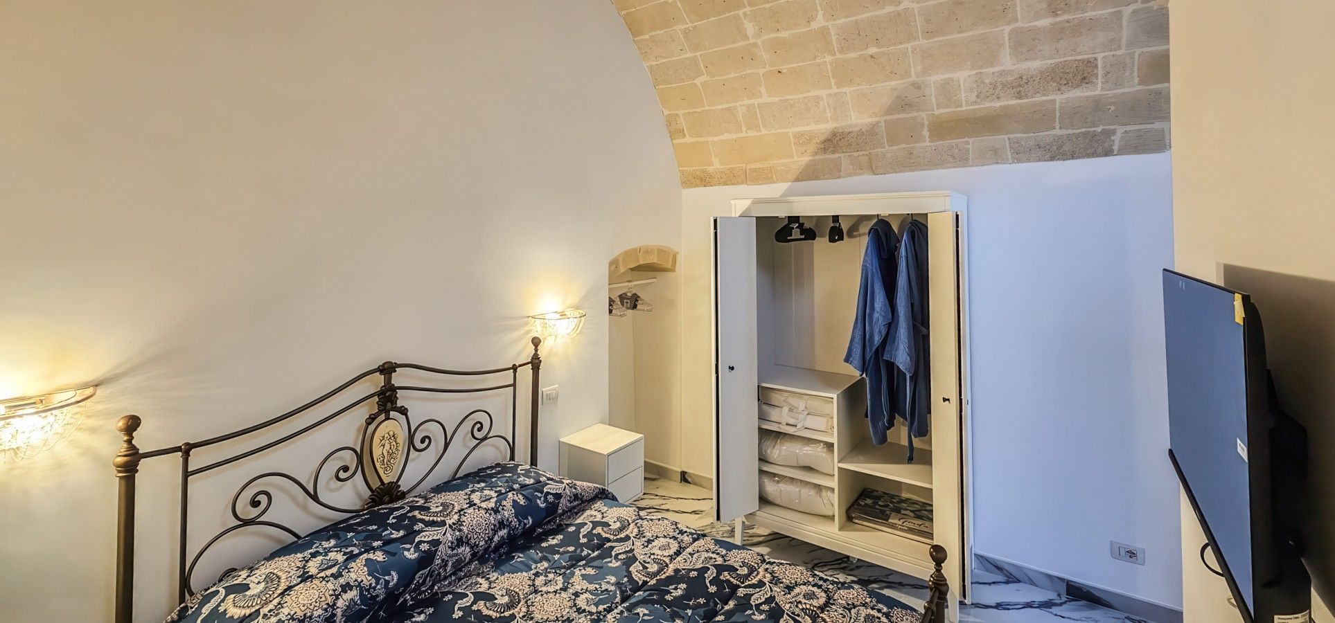 Une chambre à coucher avec un lit, une armoire et un téléviseur.