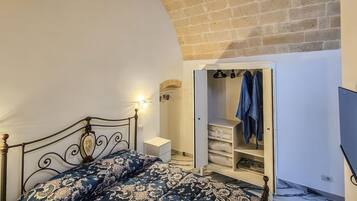 Une chambre à coucher avec un lit, une armoire et un téléviseur.