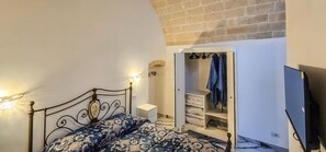 Une chambre à coucher avec un lit, une armoire et un téléviseur.