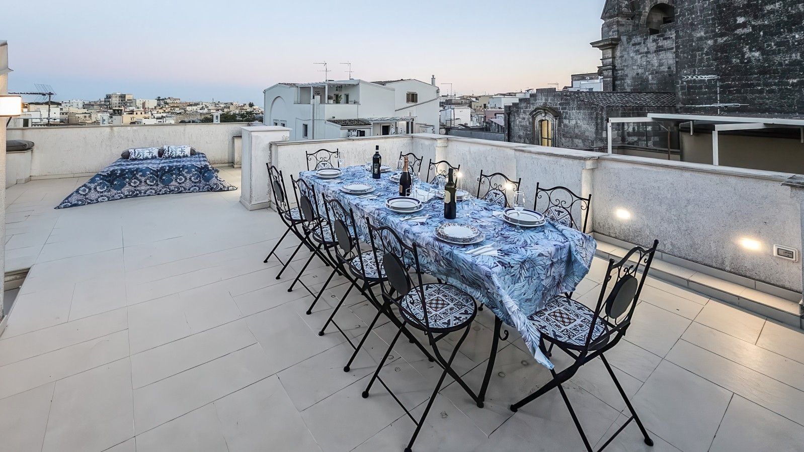 Une terrasse sur le toit avec une table à manger pour six personnes, entourée de chaises.