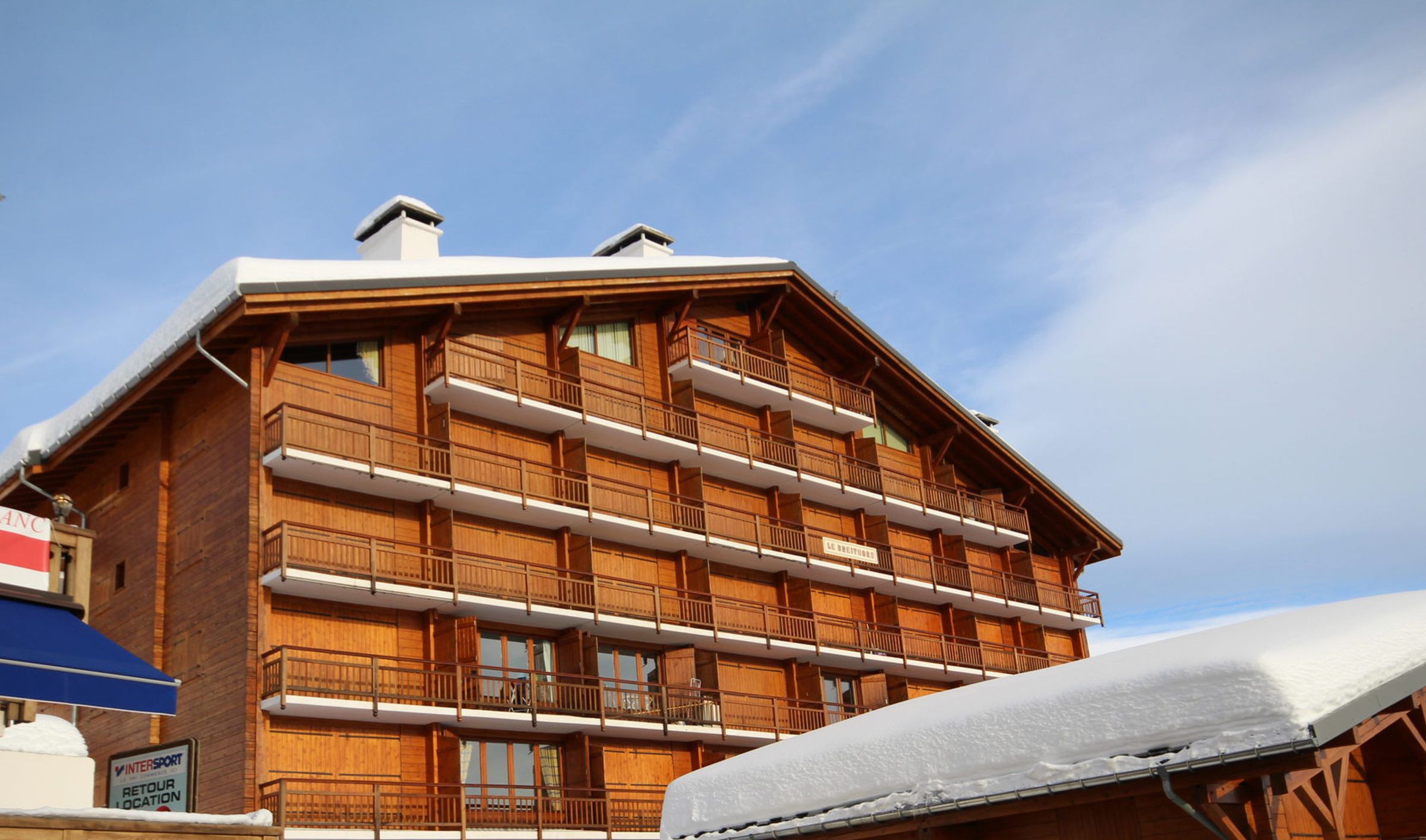 A multi-story wooden building with balconies, likely a hotel or lodge.