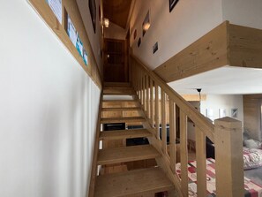 A wooden staircase with a handrail, leading to a bedroom with a bed and a quilt. - Apartment 8 guests, pets welcome, mountain view (Villard-sur-Doron)