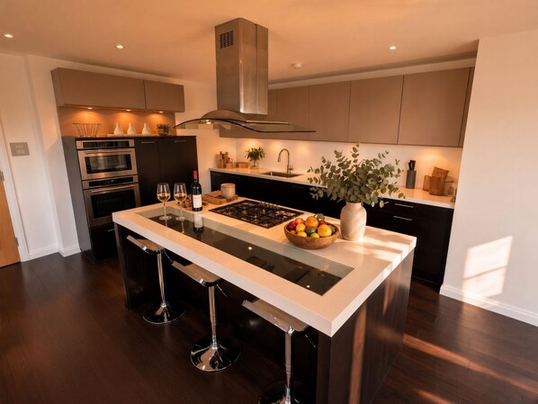 A modern kitchen with a central island, stainless steel appliances, and a large window.