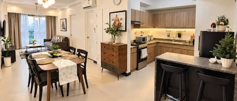 A modern kitchen with wooden cabinets, a built-in oven, and a dining area with a table set for four.
