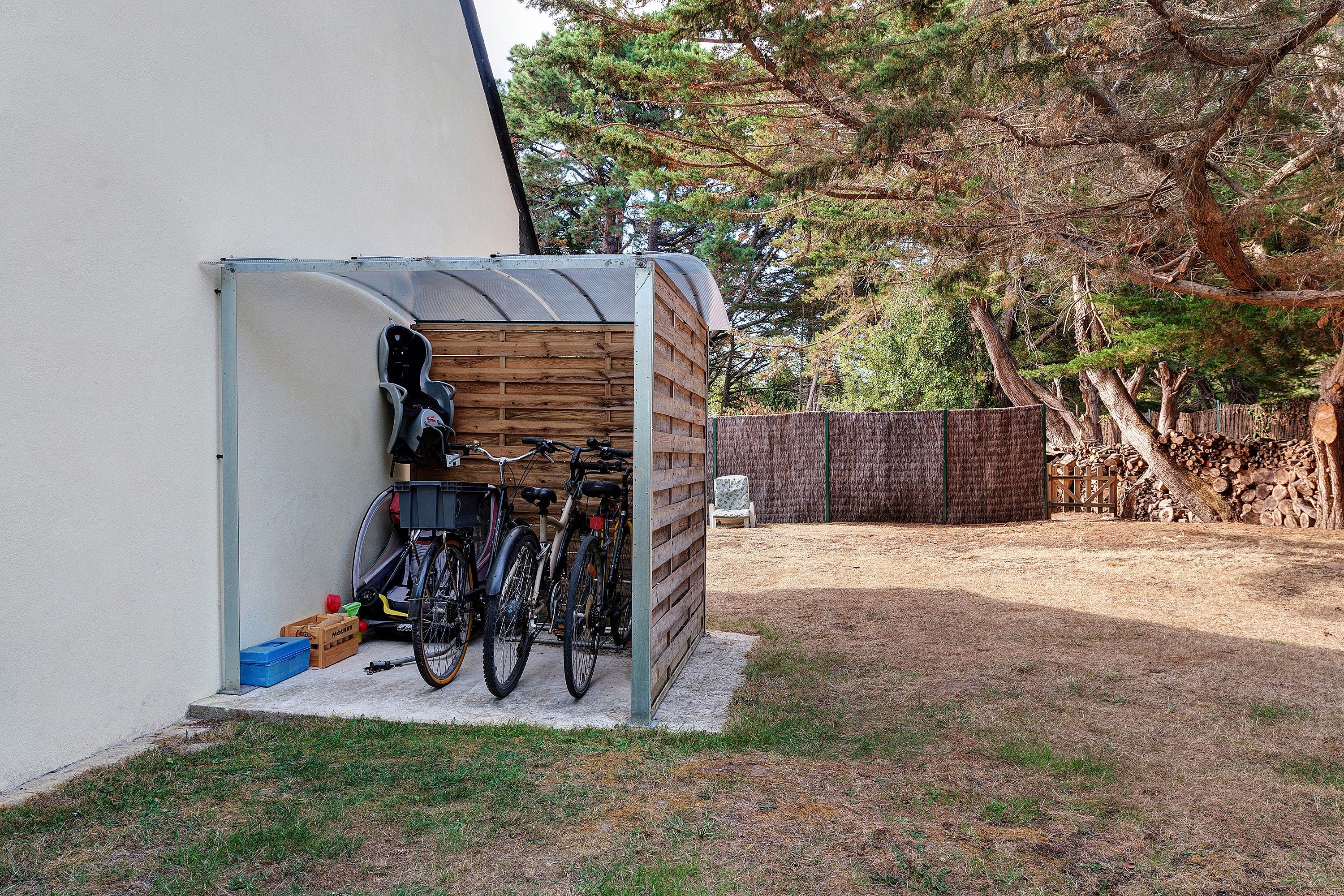 A covered outdoor area with bicycles and storage boxes.