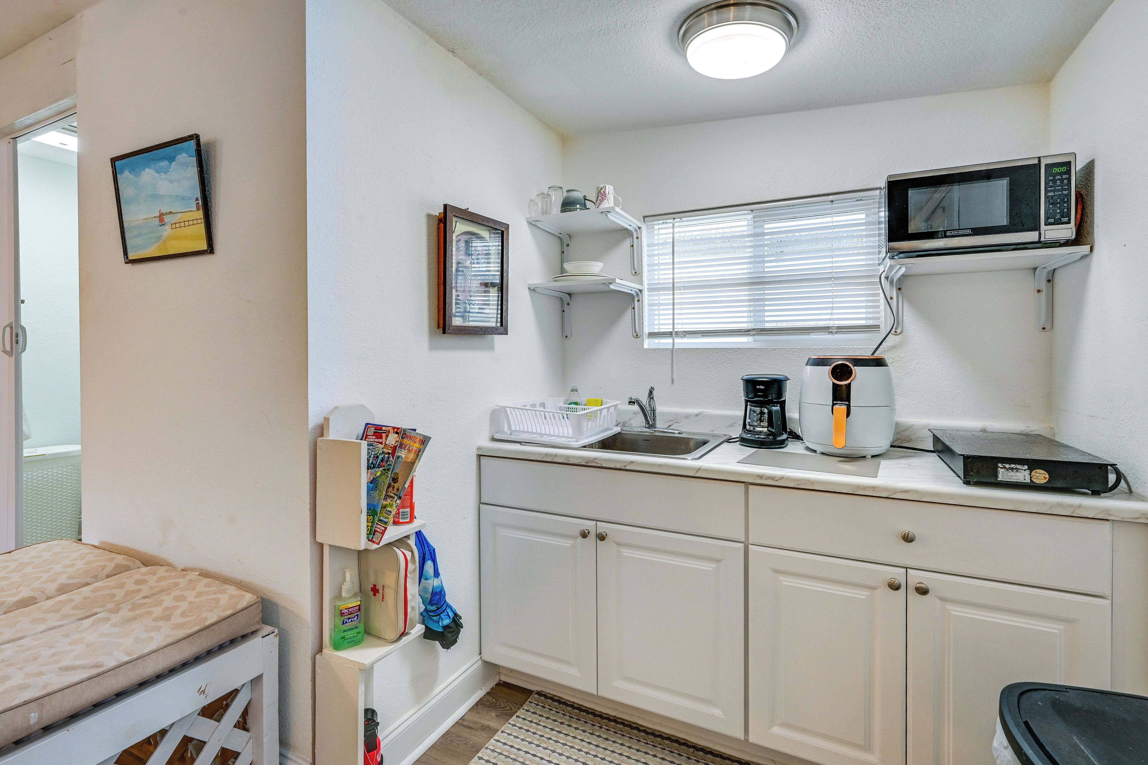 A compact kitchen with a sink, a microwave, and a coffee maker.