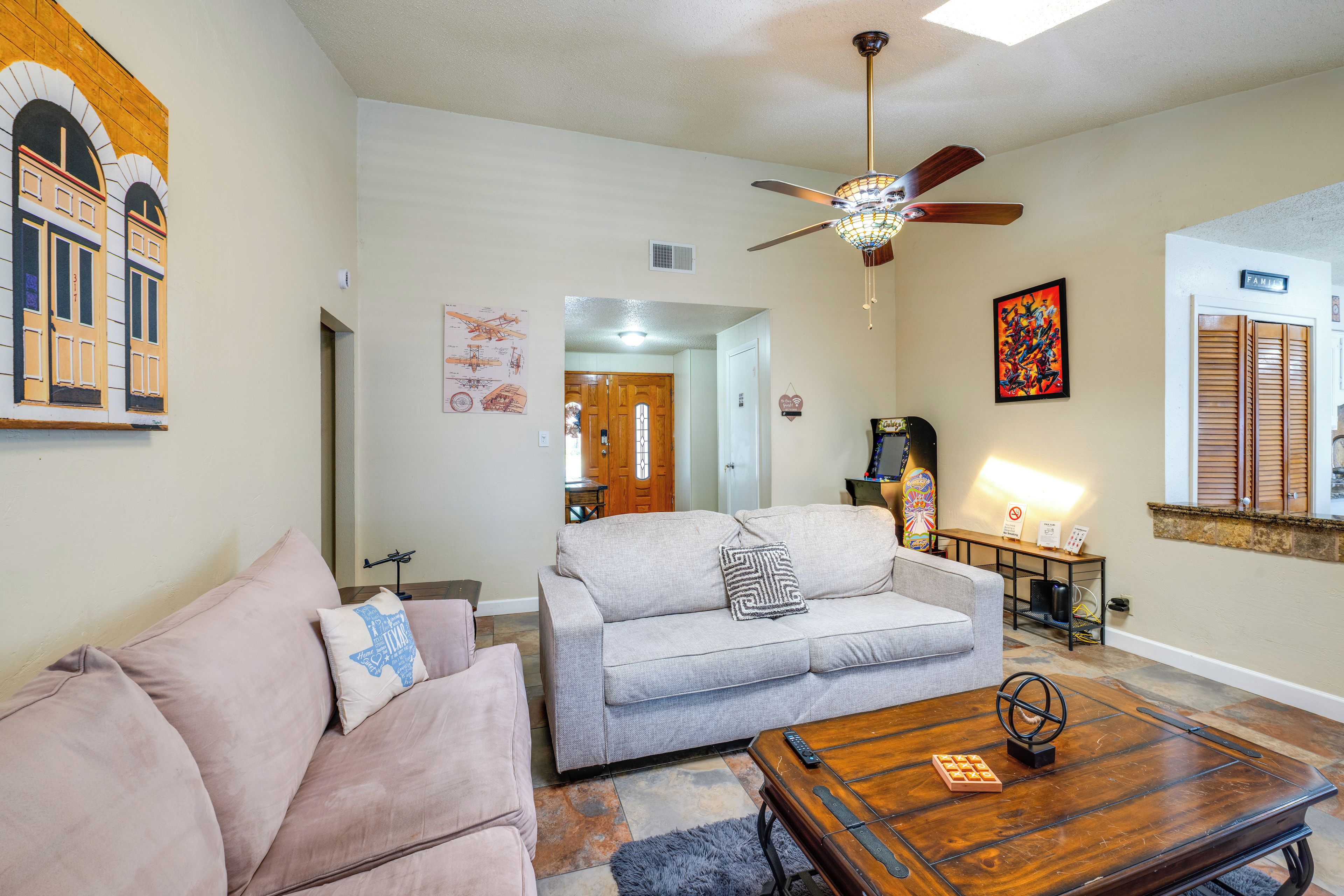 A living room with a sofa, a coffee table, and a ceiling fan.