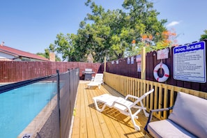 A backyard pool area with a wooden deck, lounge chairs, and a pool rules sign. - Family-friendly Home w/ Hot Tub in San Antonio! (San Antonio)