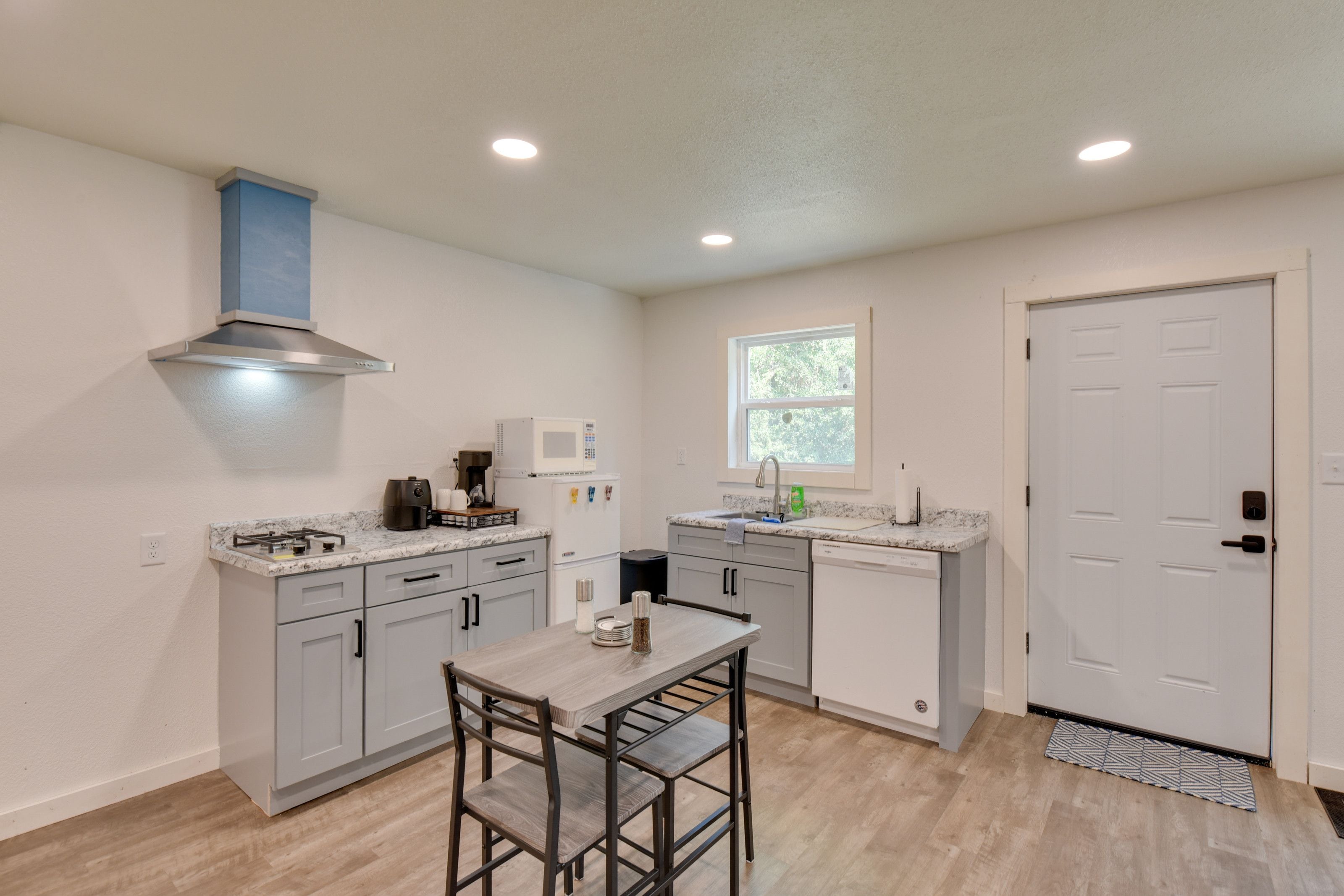 A compact kitchen with a gas stove, microwave, and a window.