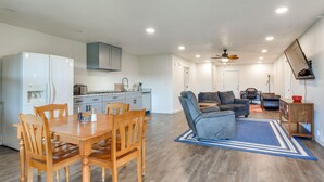 A modern kitchen with a dining area, a gray sofa, and a ceiling fan. - 2 Red Level Rentals on a Working Farm! (Red Level)