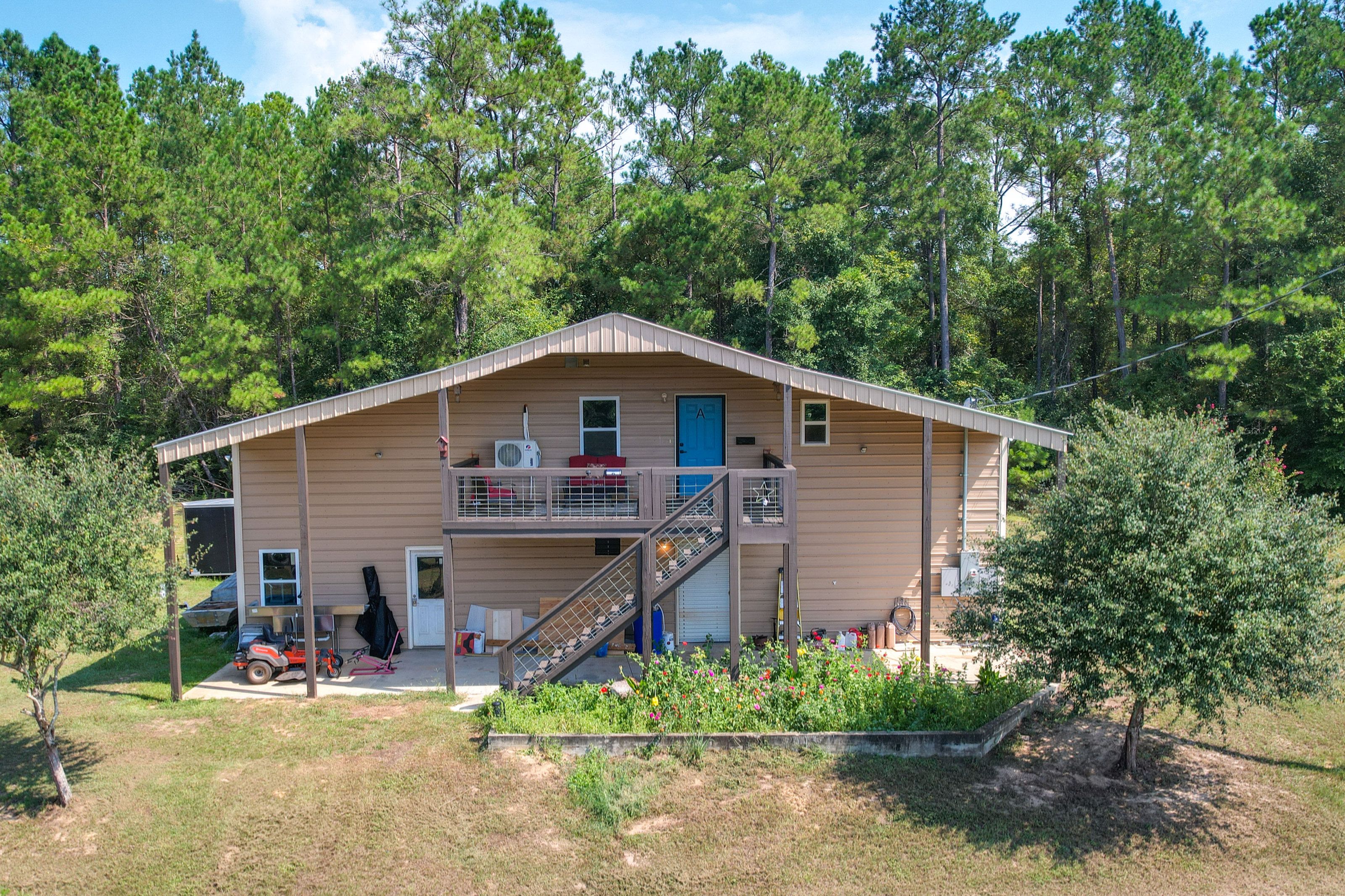 A two-story cabin with a balcony, a staircase, and a small porch area.