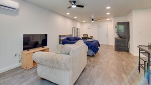 A modern living room with a flat-screen TV, a sofa, a coffee table, and a ceiling fan. - 2 Red Level Rentals on a Working Farm! (Red Level)