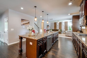 A spacious kitchen with a central island, wooden cabinets, and a stainless steel dishwasher.