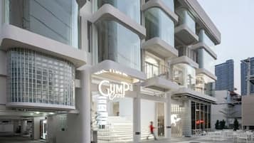 A modern building with a prominent 'GUMPO'S' sign, large windows, and a pedestrian area with seating.