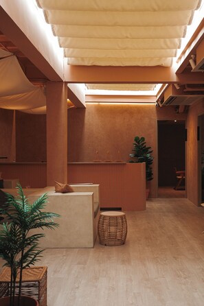 A modern interior with a reception desk, seating area, and a plant. - Apt. CAI 04 Aparthotel (Krung Thep Maha Nakhon)