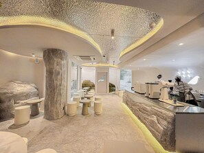 A modern interior with a central seating area, a reception desk, and a large column. - Apt. CAI 04 Aparthotel (Krung Thep Maha Nakhon)