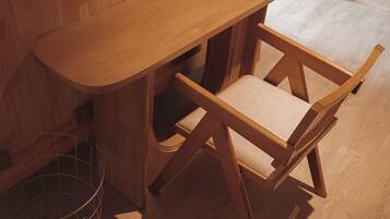 Un bureau en bois avec une chaise, un panier en métal et un plancher en bois.