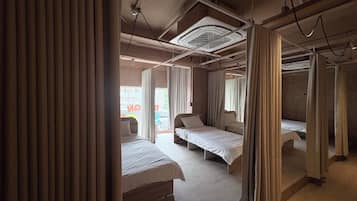 Una habitación de hotel con cama, ventana y ventilador de techo.