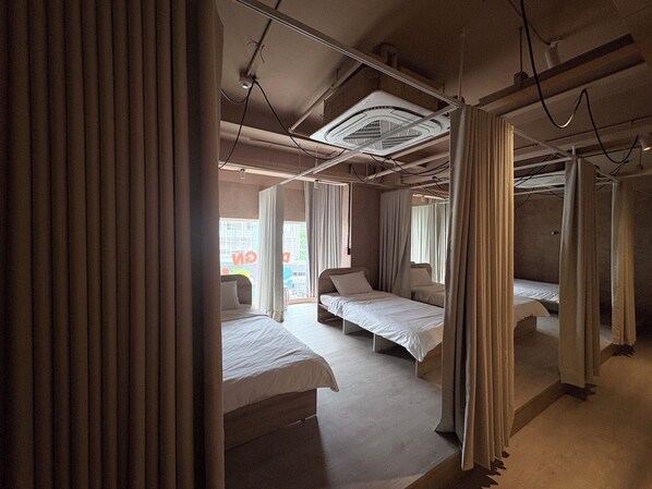 A hotel room with a bed, a window, and a ceiling fan.