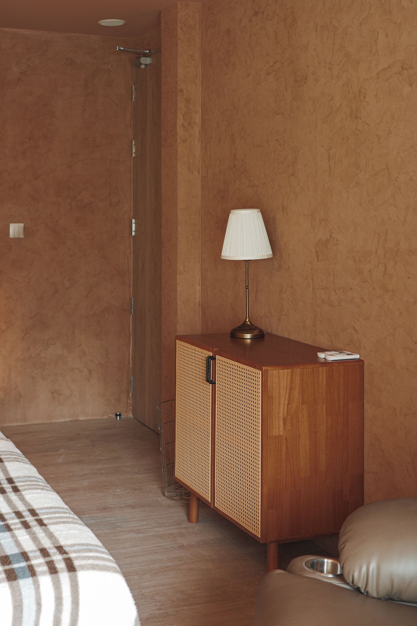 Une chambre d’hôtel avec un meuble en bois, une lampe, un lit et un bol pour animaux de compagnie.